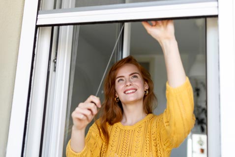 Frau öffnet Fenster